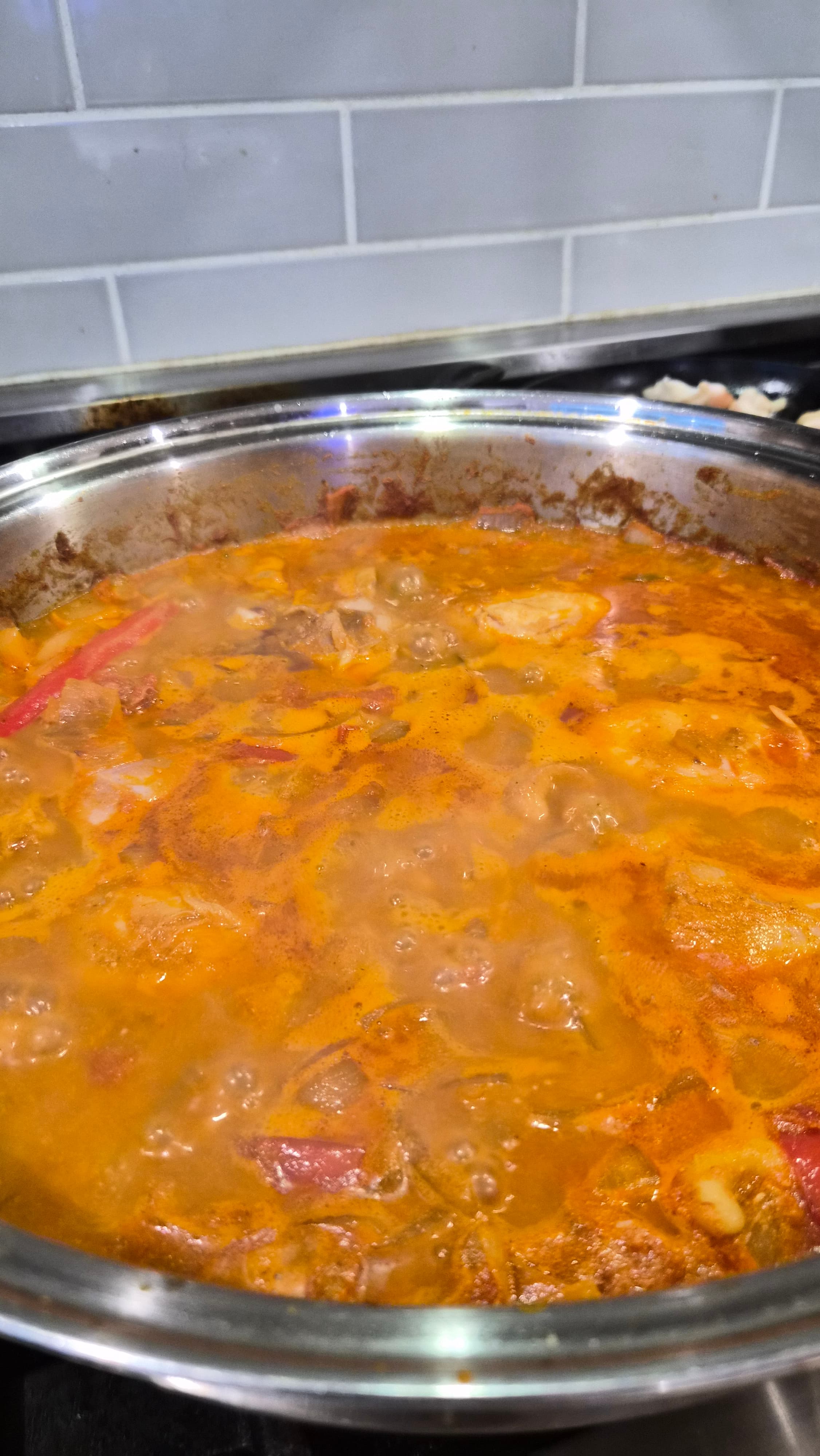 A pan of butter chicken kabsa simmering on the stove